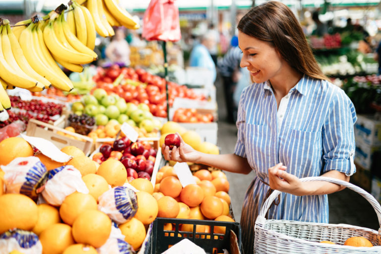 Mulher escolhendo frutas no mercado