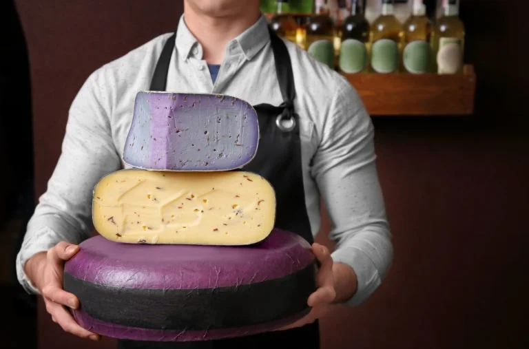 Homem segurando tipos diferentes de queijos