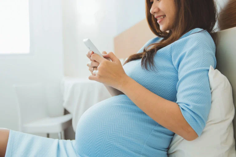 Mulher grávida marcando consultas e exames pelo celular