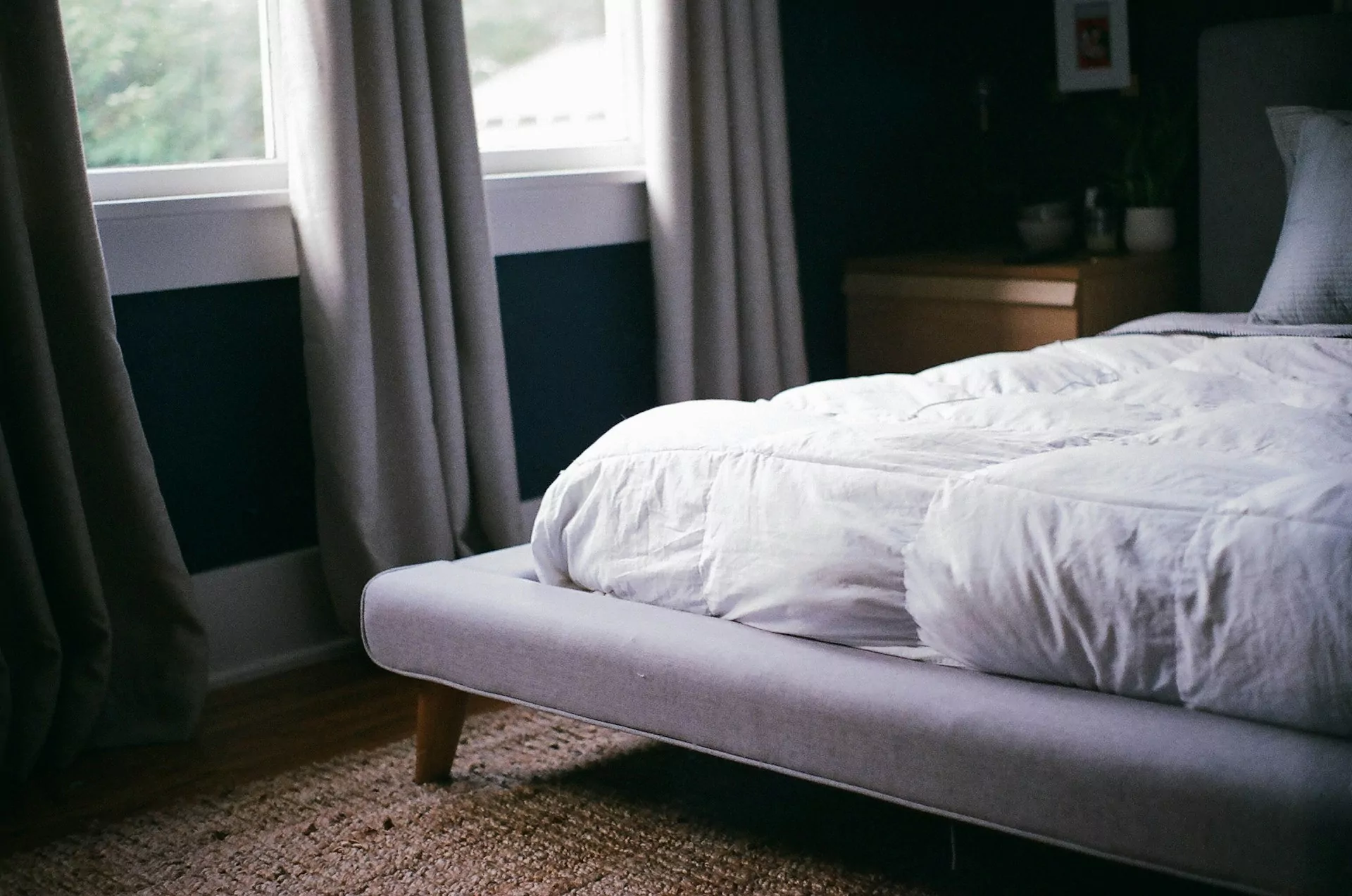 Cama de casal com cobertor branco.