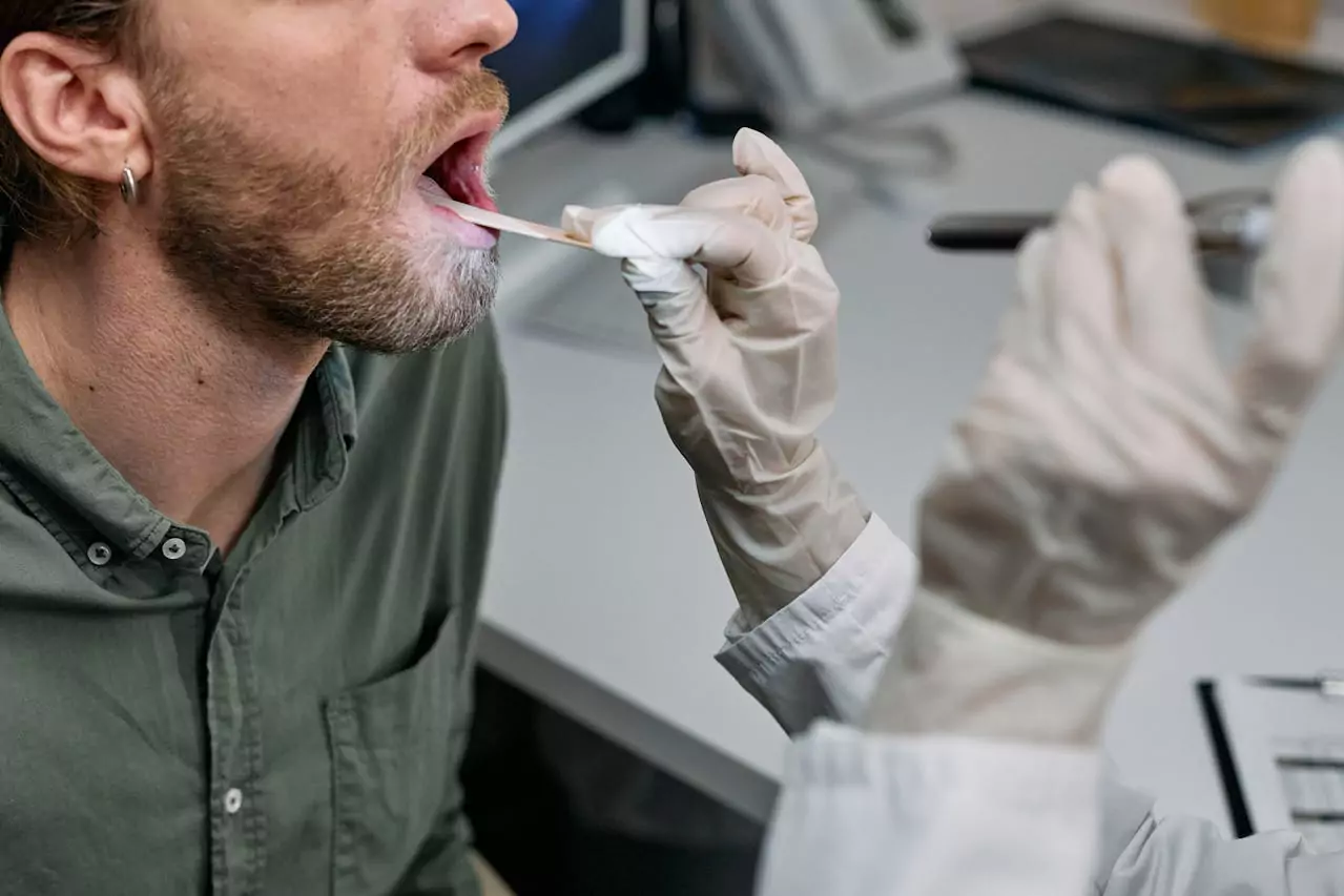 Médico examinando a boca de paciente.