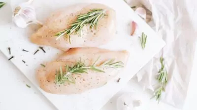 Filés de frango em cima de uma tábua de corte.