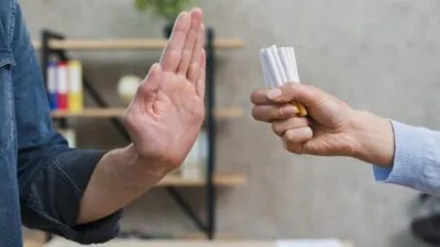Homem, detalhe de suas mãos, recusa maço de cigarros, oferecido.